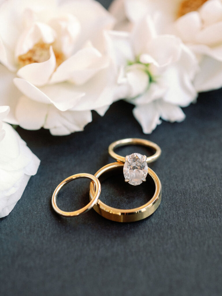 wedding rings with white florals wedding details photography