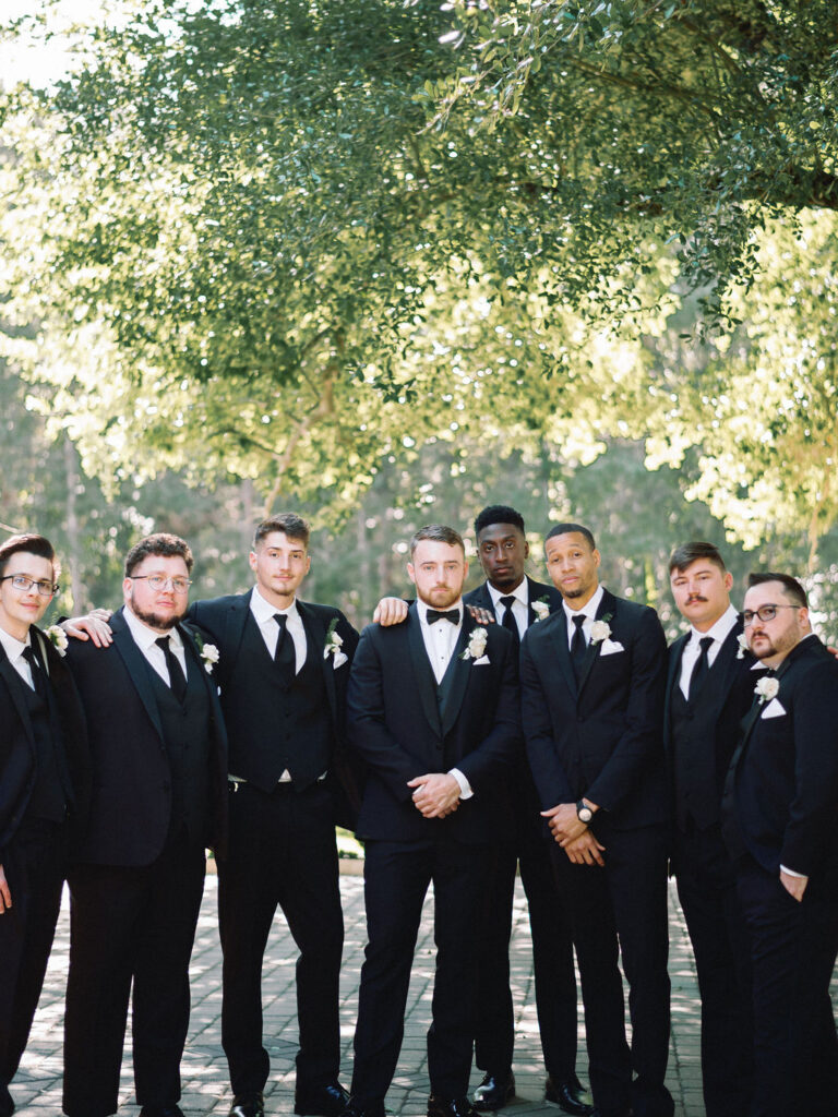 groomsmen standing in a line editorial pose